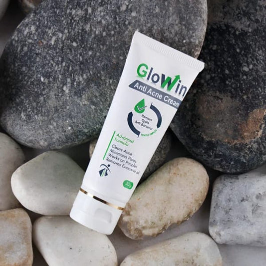 Glowin Anti Acne Cream tube on a stone background